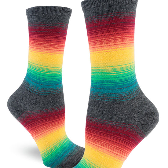 Crew socks for women with thin rainbow gradient stripes in muted tones between larger stripes of gray.
