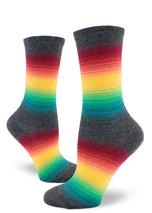 Crew socks for women with thin rainbow gradient stripes in muted tones between larger stripes of gray.