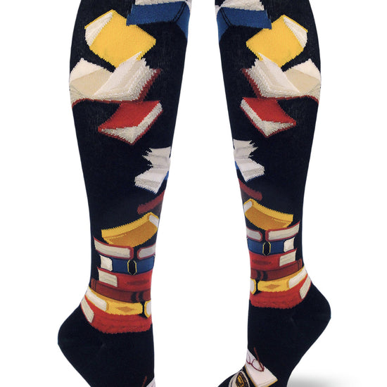 Black knee socks with stacked multicolored books, flying books at the top and an open book with glasses and cup below.
