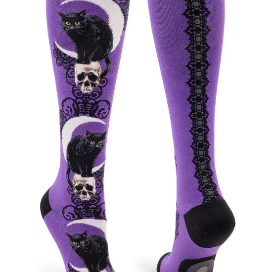 Purple knee-high socks with black cat, moon and skull pattern down the front and lace ribbon back seam.