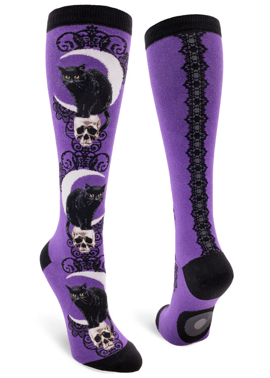 Purple knee-high socks with black cat, moon and skull pattern down the front and lace ribbon back seam.