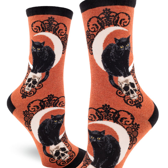 Rust orange crew socks for women with black cats, crescent moons, skulls and black lace pattern.