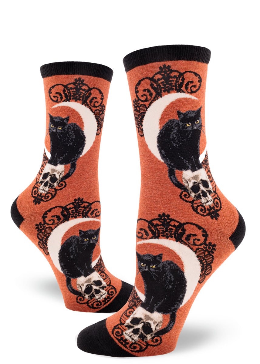 Rust orange crew socks for women with black cats, crescent moons, skulls and black lace pattern.