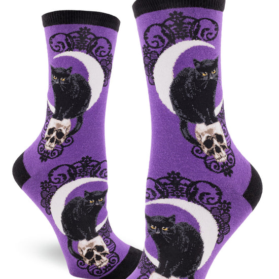 Purple crew socks for women with black cat and skull pattern, crescent moon and black lace.