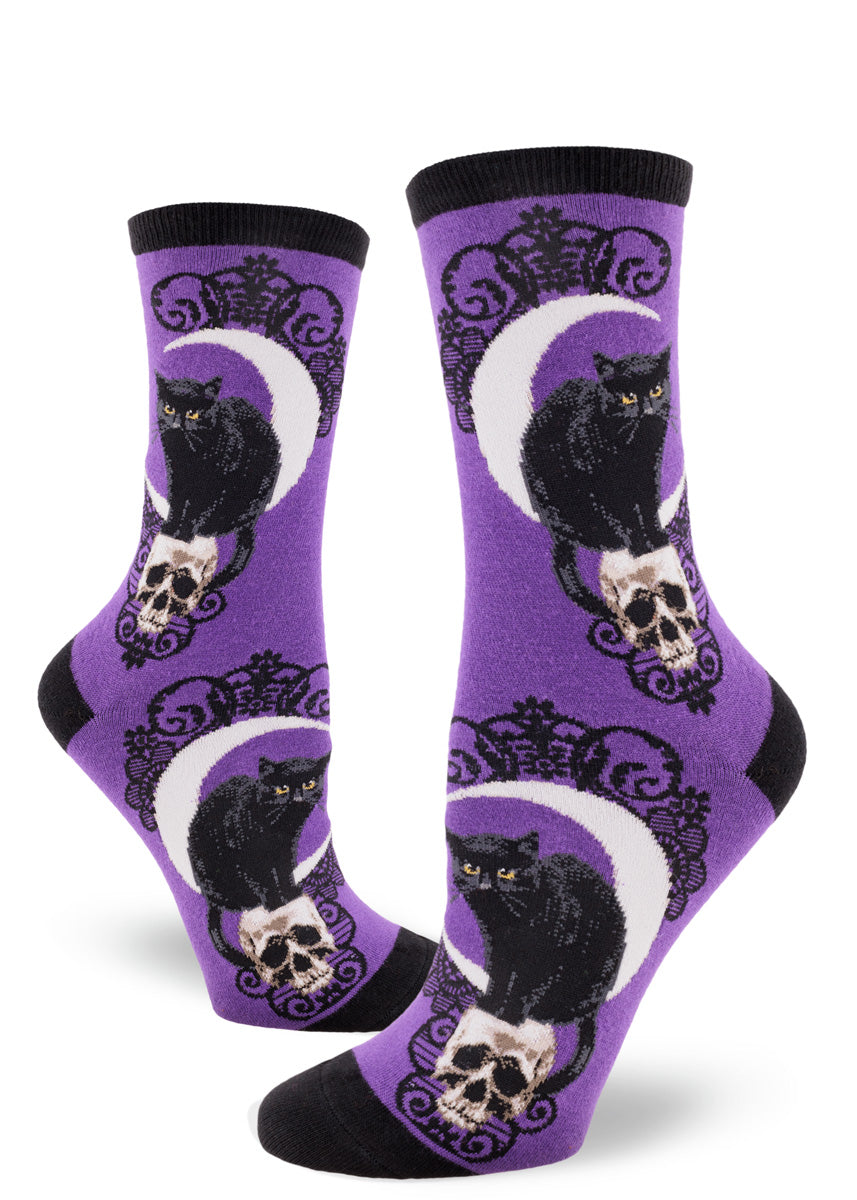 Purple crew socks for women with black cat and skull pattern, crescent moon and black lace.