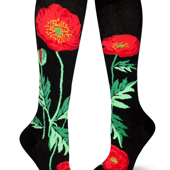 Black knee socks with floral design of large red poppy flowers on green stems and leaves.