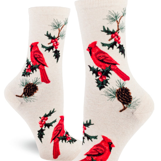 Cream crew socks for women with red cardinal birds, sprigs of holly and pinecones with pine needles.