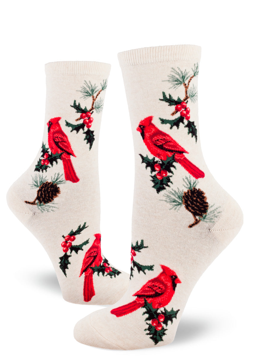 Cream crew socks for women with red cardinal birds, sprigs of holly and pinecones with pine needles.