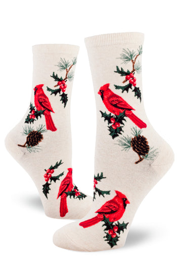 Cream crew socks for women with red cardinal birds, sprigs of holly and pinecones with pine needles.
