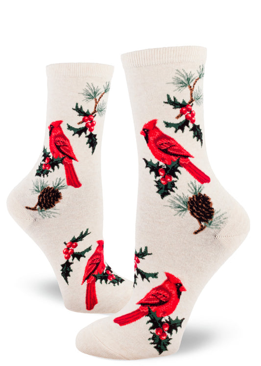 Cream crew socks for women with red cardinal birds, sprigs of holly and pinecones with pine needles.