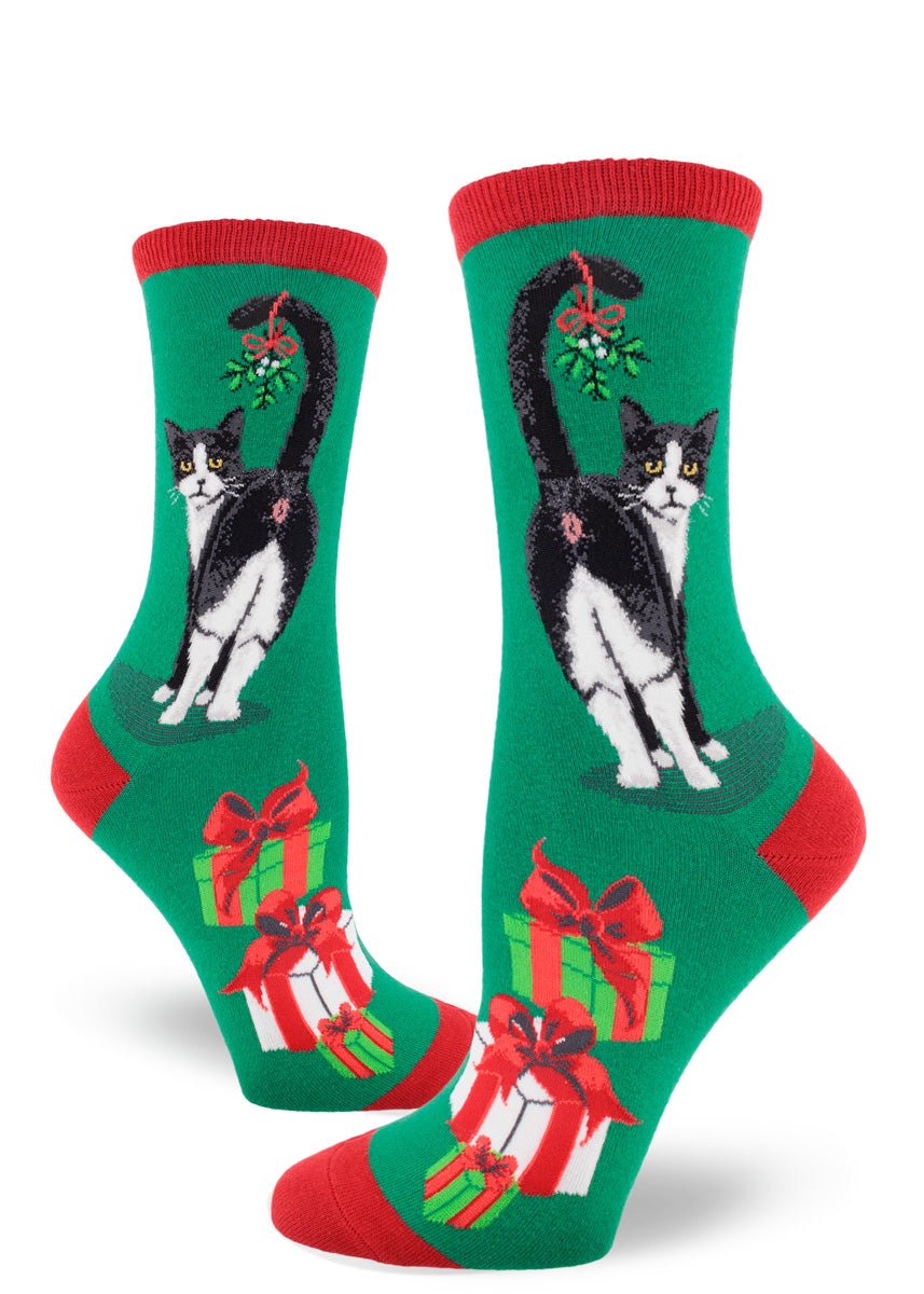 Red and green Christmas crew socks for women with black and white cats showing their butts with mistletoe on their tails and wrapped presents.