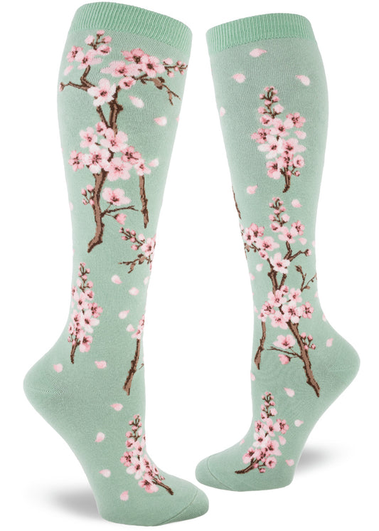 Pale green knee socks with branches of pink cherry blossoms and falling pink petals.