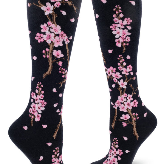 Darn navy knee-high socks with pink cherry blossoms on branches with petals drifting.