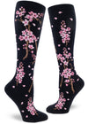 Darn navy knee-high socks with pink cherry blossoms on branches with petals drifting.