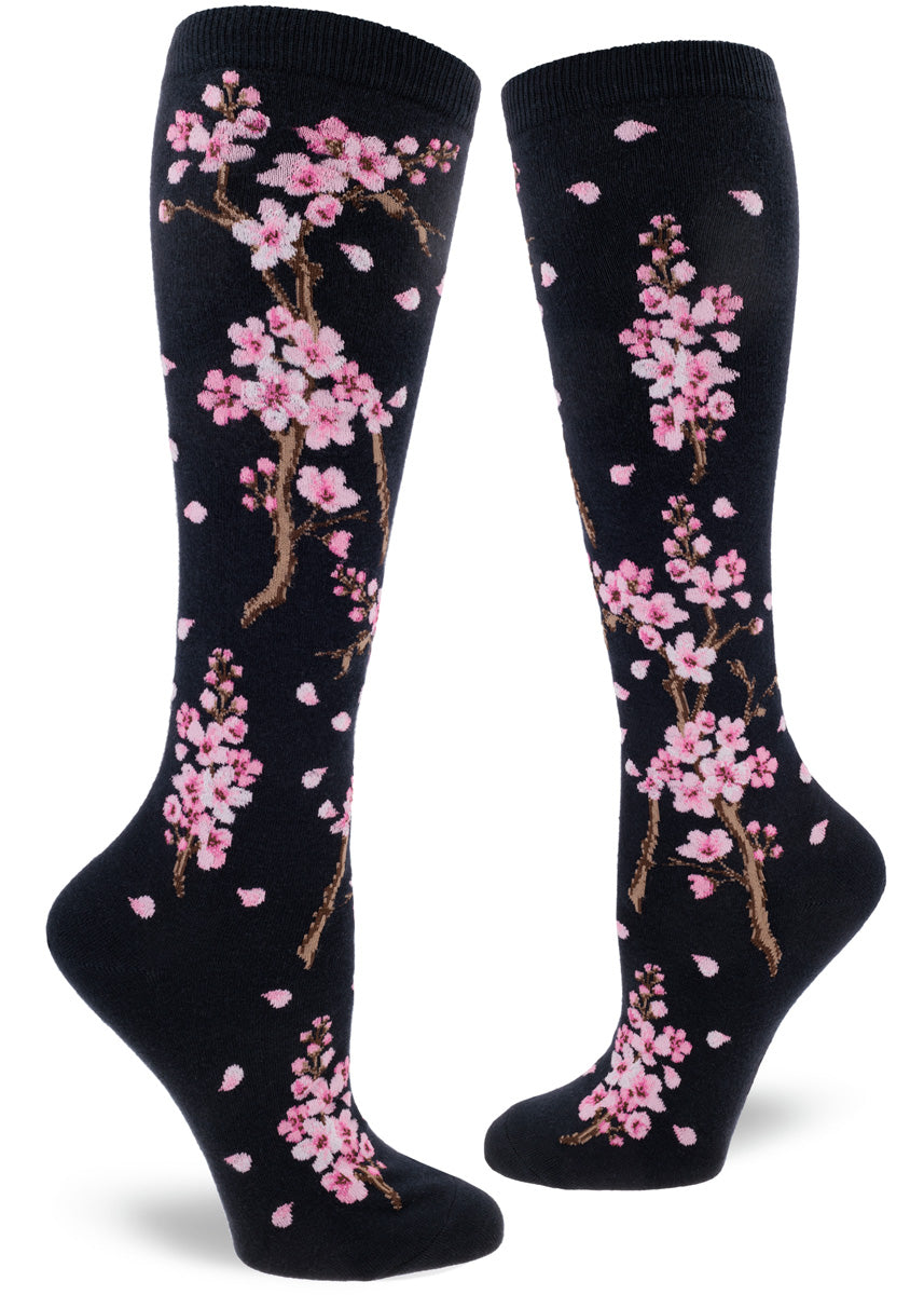 Darn navy knee-high socks with pink cherry blossoms on branches with petals drifting.