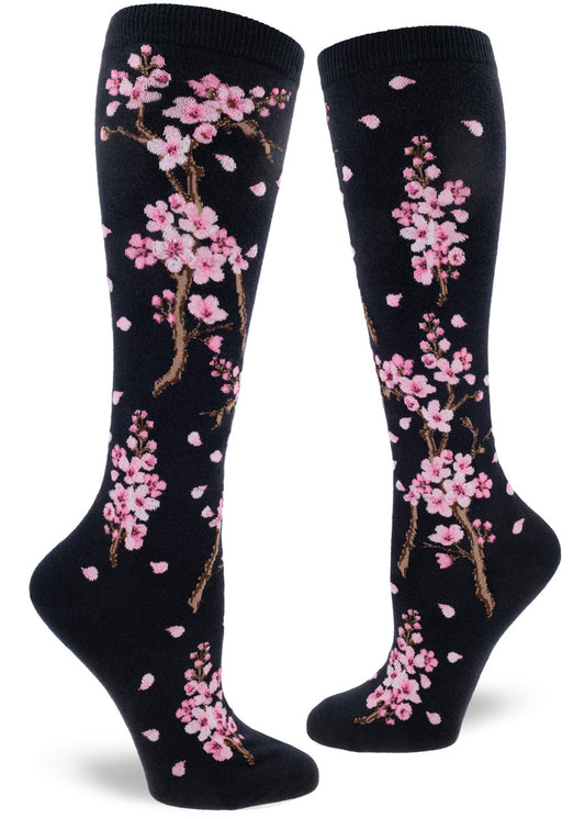 Darn navy knee-high socks with pink cherry blossoms on branches with petals drifting.