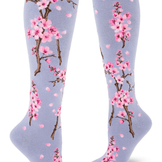 Floral knee socks with an allover pattern of pink cherry blossoms on a light purple background.