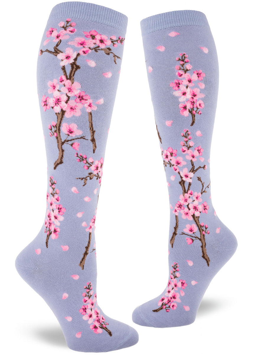 Floral knee socks with an allover pattern of pink cherry blossoms on a light purple background.