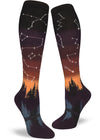 Knee-high socks with sunset glow gradient of purple and orange and star constellations over a forest and lake.