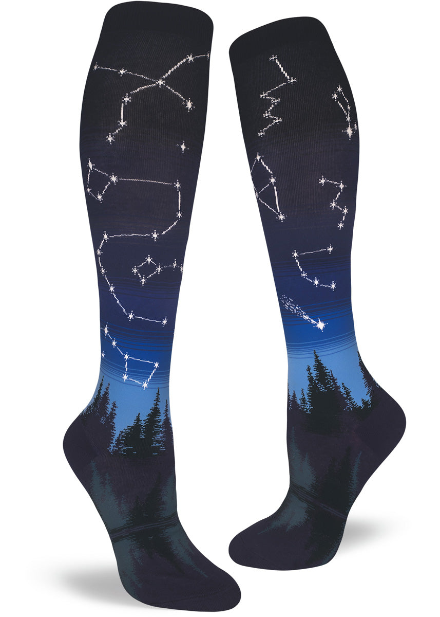 Blue gradient knee socks with night sky pattern and stars in constellations above a forest and lake.