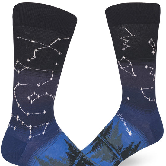 Blue crew socks for men with star constellation design in night sky above a forest and lake.
