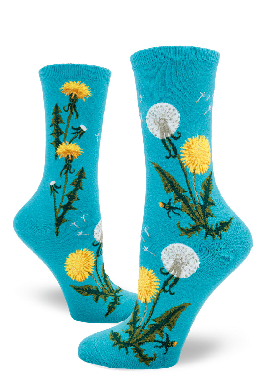 Blue crew socks for women with dandelion flowers and seed heads along with seeds flying.