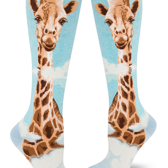 Blue knee socks with giant realistic giraffe head rising over clouds.