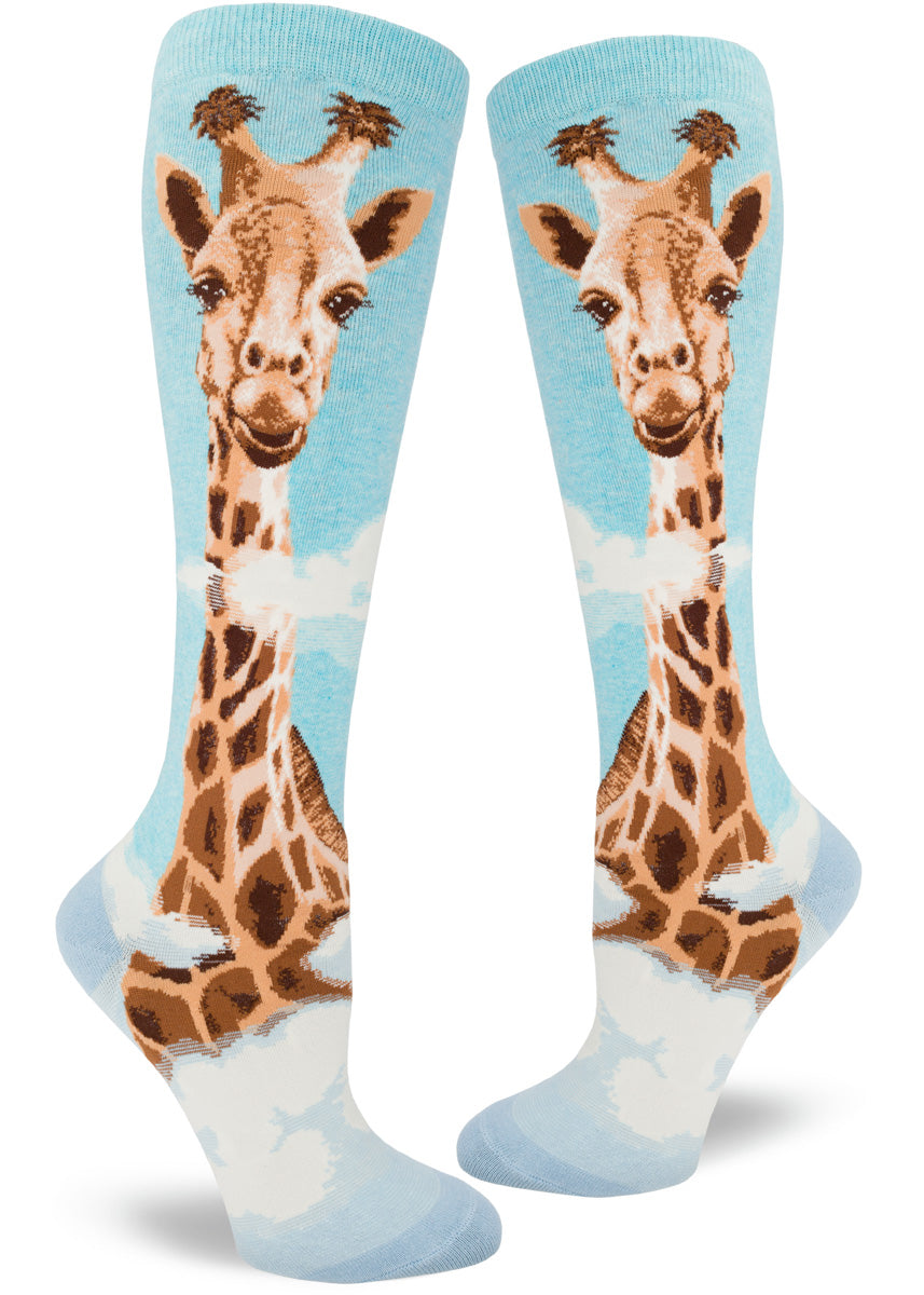 Blue knee socks with giant realistic giraffe head rising over clouds.