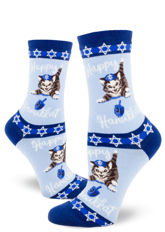 Blue crew socks for women with playful cats in yarmulkes, dreidels and stars of David with the words "Happy Hanukkat."
