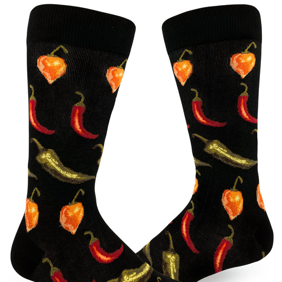 Black crew socks for men with allover repeating pattern of spicy orange, red and green chili peppers.
