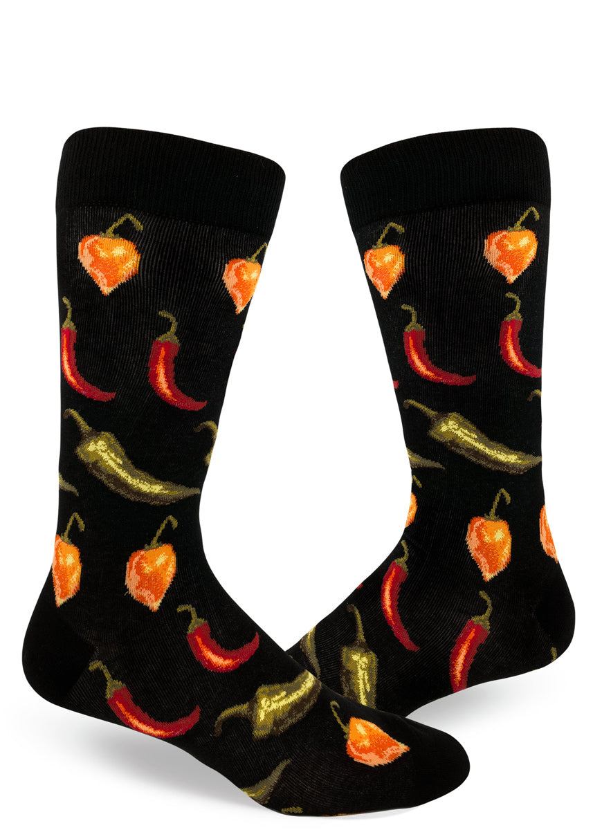 Black crew socks for men with allover repeating pattern of spicy orange, red and green chili peppers.
