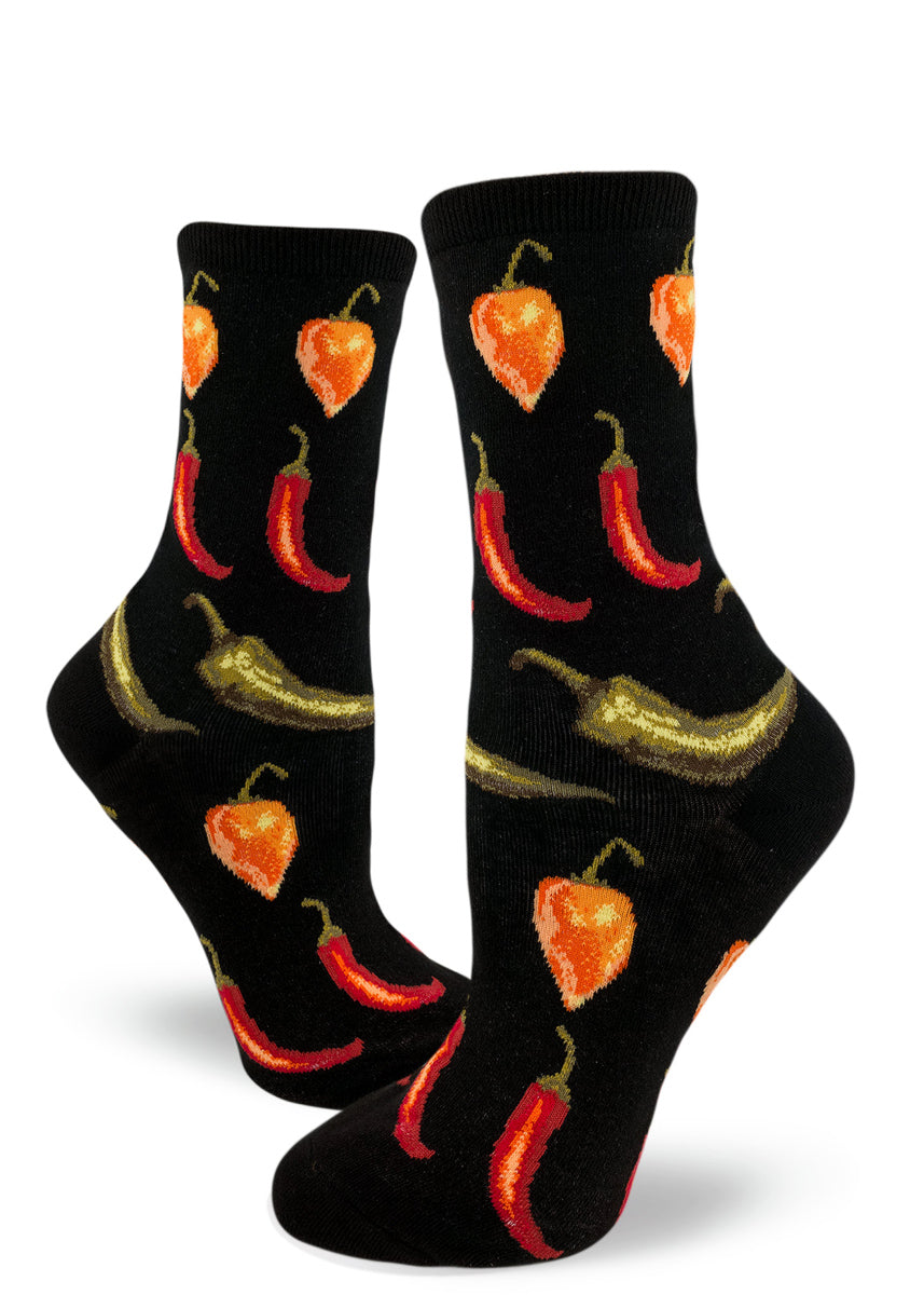 Women's crew socks with repeating pattern of red, orange and green hot peppers arranged in rows against a black background.