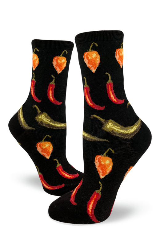 Women's crew socks with repeating pattern of red, orange and green hot peppers arranged in rows against a black background.