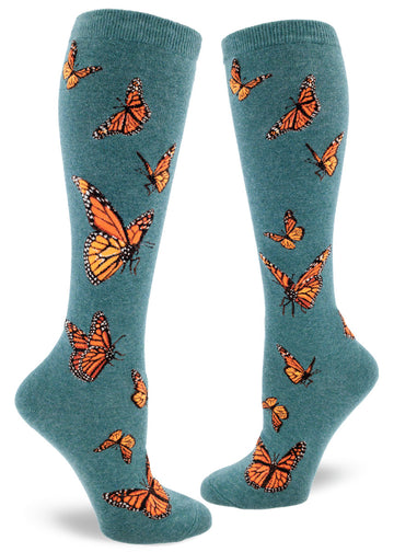 Dark teal knee socks with orange monarch butterflies in flight.