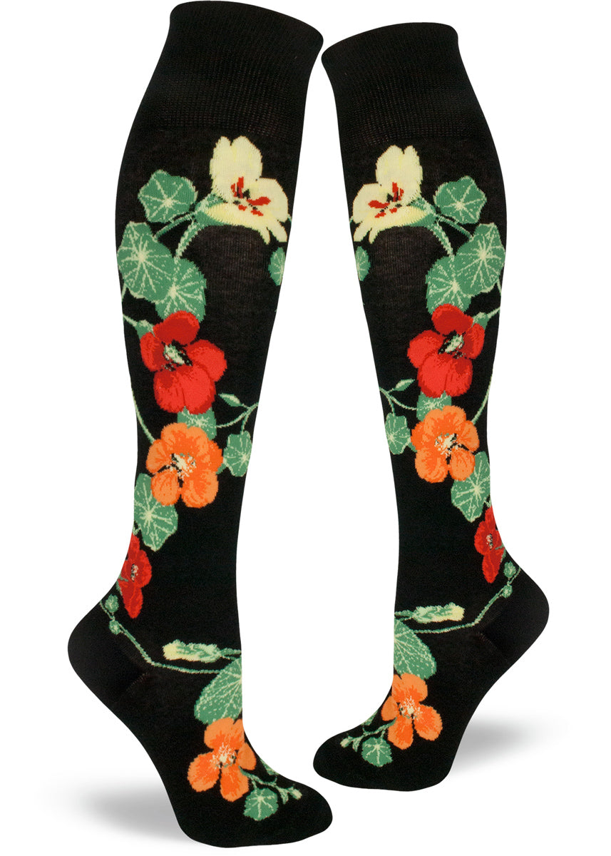 Black knee socks with colorful floral design featuring red, orange and yellow nasturtium flowers with green leaves.