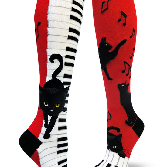 Red, black and white knee socks with black cats walking down piano keys and pawing at music notes.