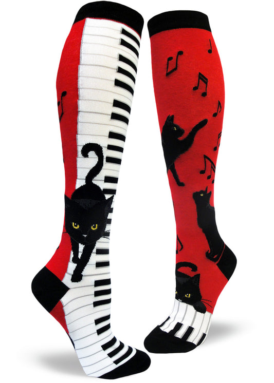 Red, black and white knee socks with black cats walking down piano keys and pawing at music notes.