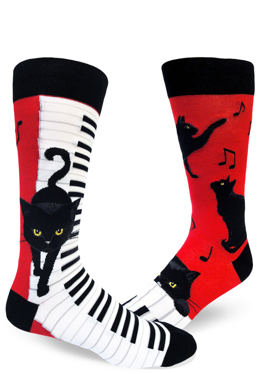 Black, white and red crew socks for men with black cats walking on piano keys and playing with music notes.