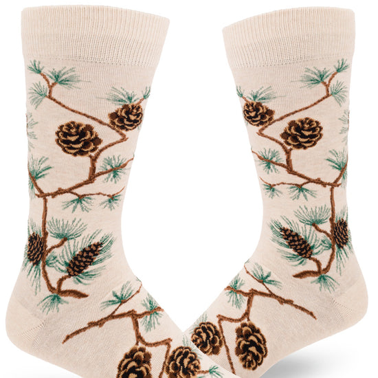Cream crew socks for men with  allover pinecone and branch design and green pine needles.