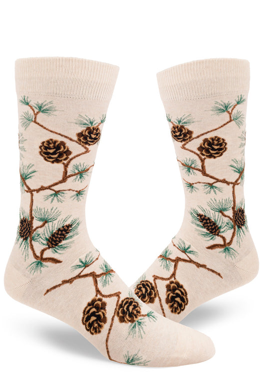 Cream crew socks for men with  allover pinecone and branch design and green pine needles.
