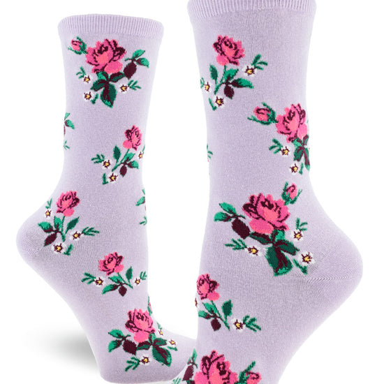 Light purple crew socks for women with allover repeating floral pattern of pink roses, small white flowers and greenery.