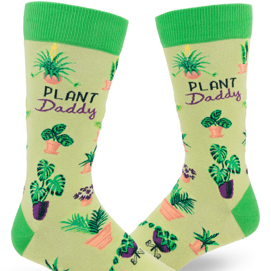 Green men's crew socks with the words "Plant Daddy" and assortment of potted houseplants.