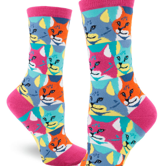 Colorful women's crew socks with allover repeating pattern of cat faces in pop art style in pink, orange, blue and yellow.