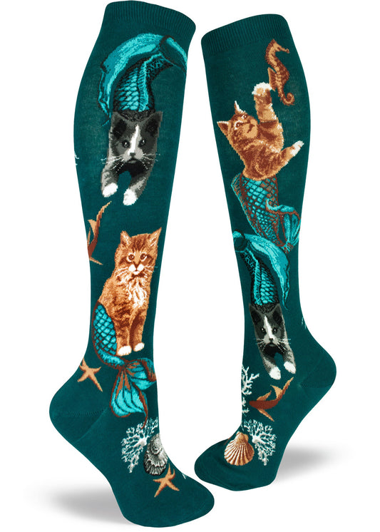 Teal knee socks with mermaid cat design of orange and black and white cats with blue tails chasing fish.
