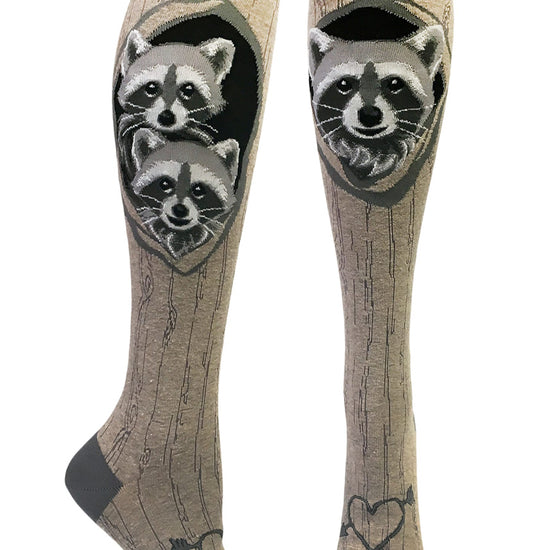 Gray knee socks with tree bark pattern and a raccoon family looking out of its den with a heart with an arrow carved at the bottom.