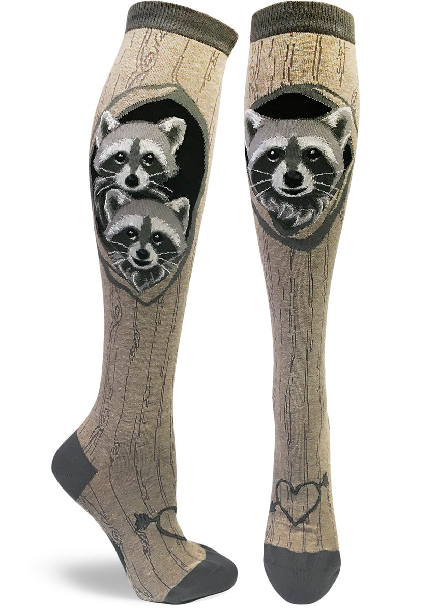Gray knee socks with tree bark pattern and a raccoon family looking out of its den with a heart with an arrow carved at the bottom.