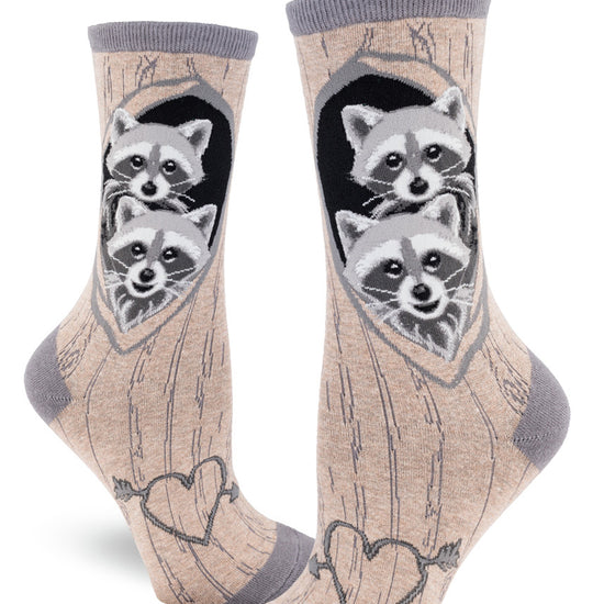 Raccoon crew socks for women with a gray brown tree bark pattern and baby raccoons peeking out of dens with a carved heat on each arch.