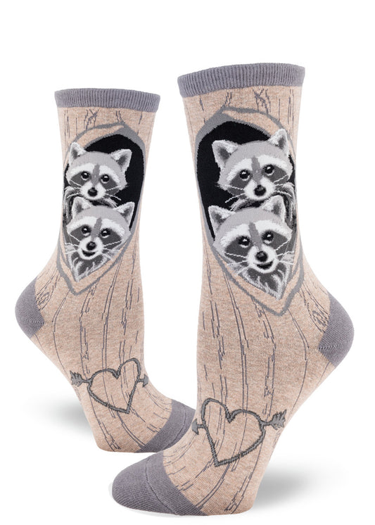 Raccoon crew socks for women with a gray brown tree bark pattern and baby raccoons peeking out of dens with a carved heat on each arch.