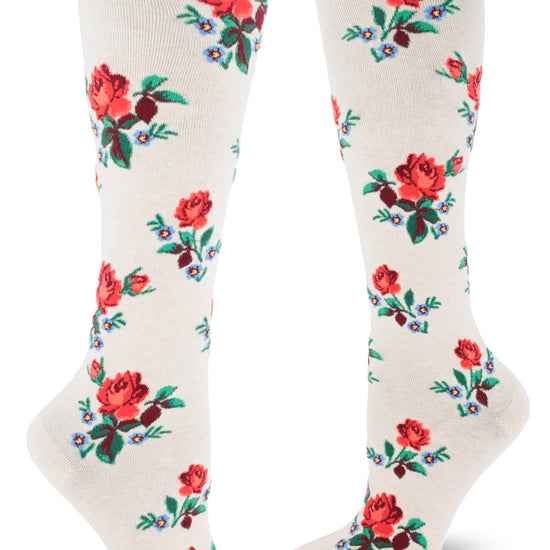 Cream knee-high socks with allover repeating floral pattern of red roses and blue forget-me-nots.
