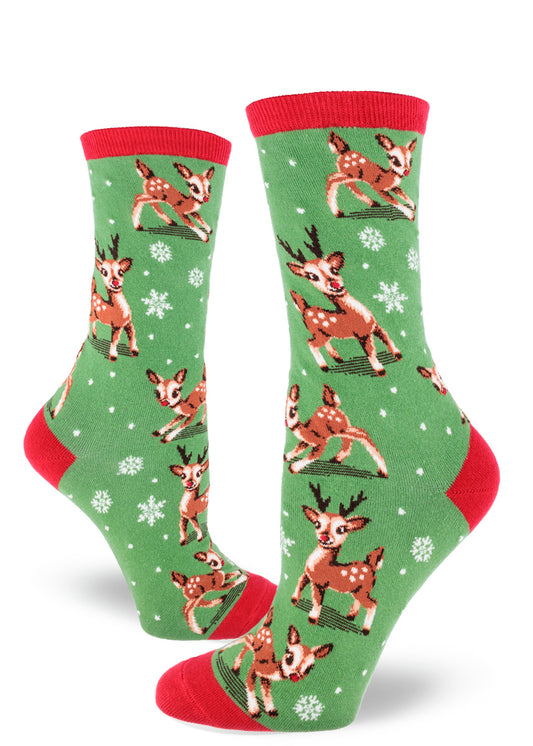 Green women's crew socks feature Christmas reindeer playing among snowflakes, with red cuffs and accents.